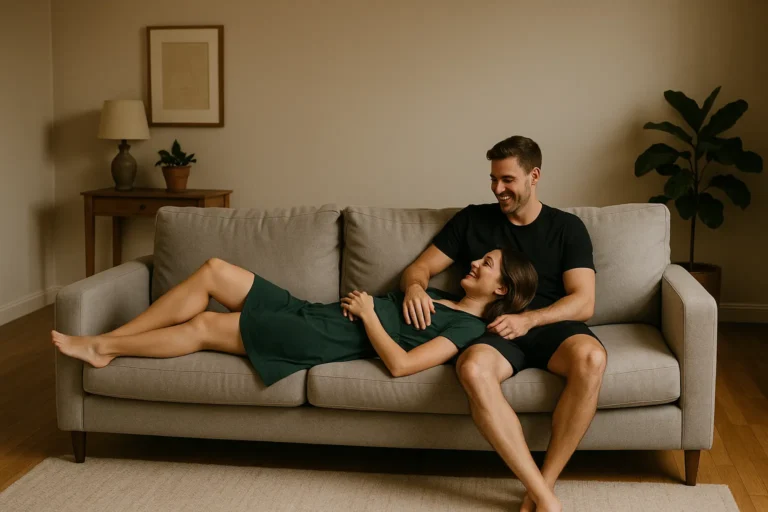 Couple relaxing on a sofa while smiling warmly at each other during a calm conversation – The Desire Talk intimacy guide